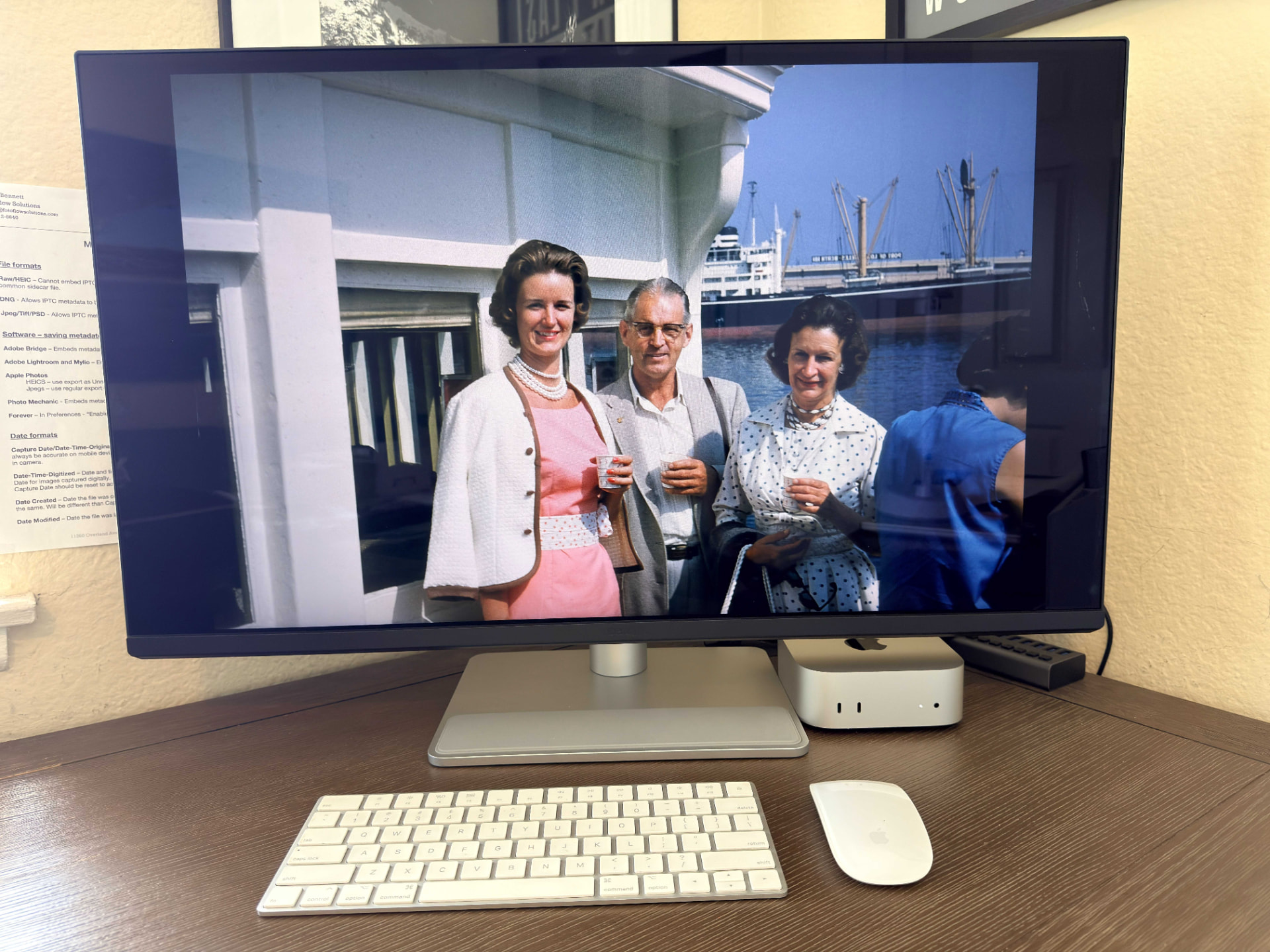 A family slideshow displayed on a desktop monitor showing a vintage color photo of three people