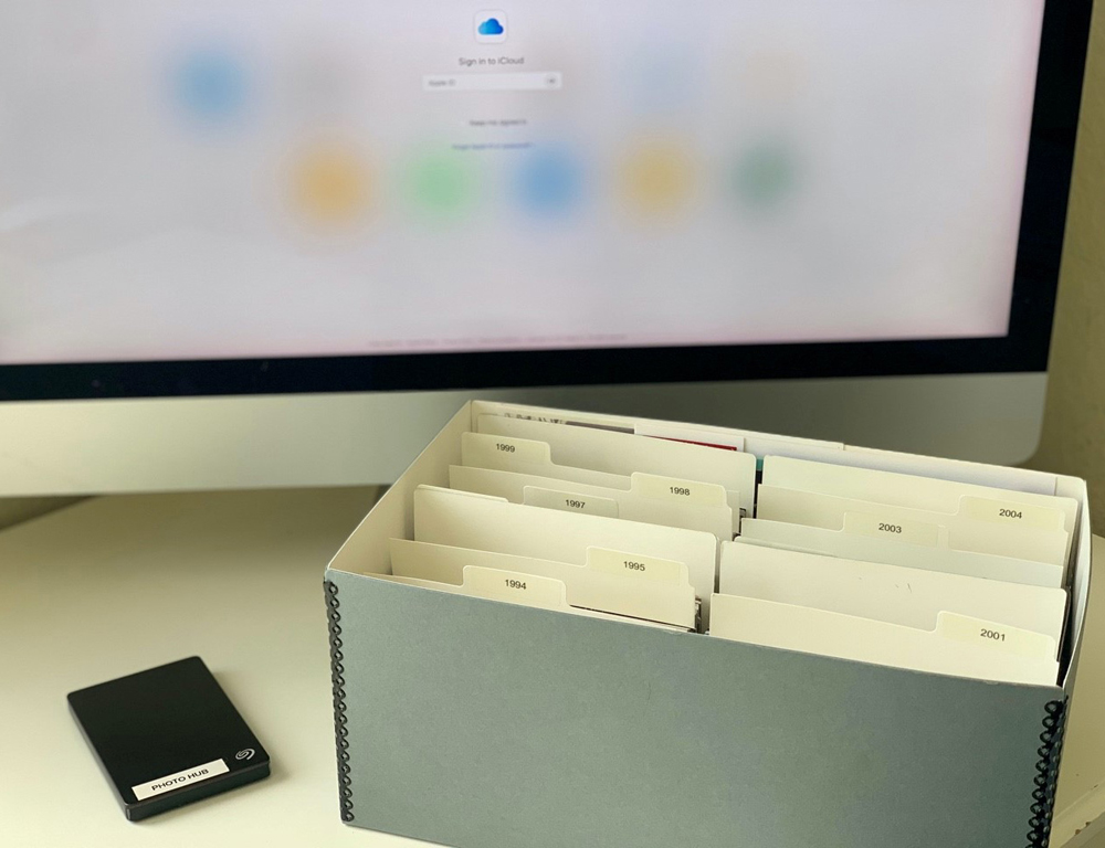 Archival photo boxes and labeled dividers on a desk